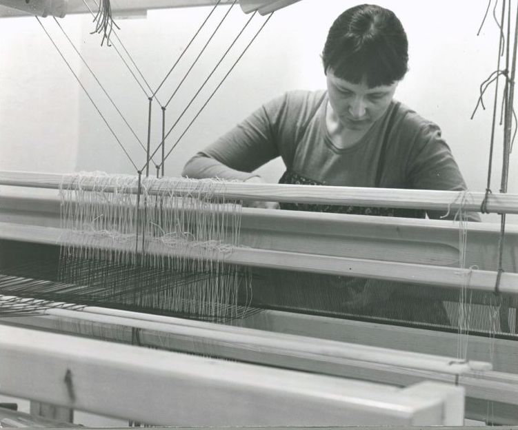 Woman weaving with looms.