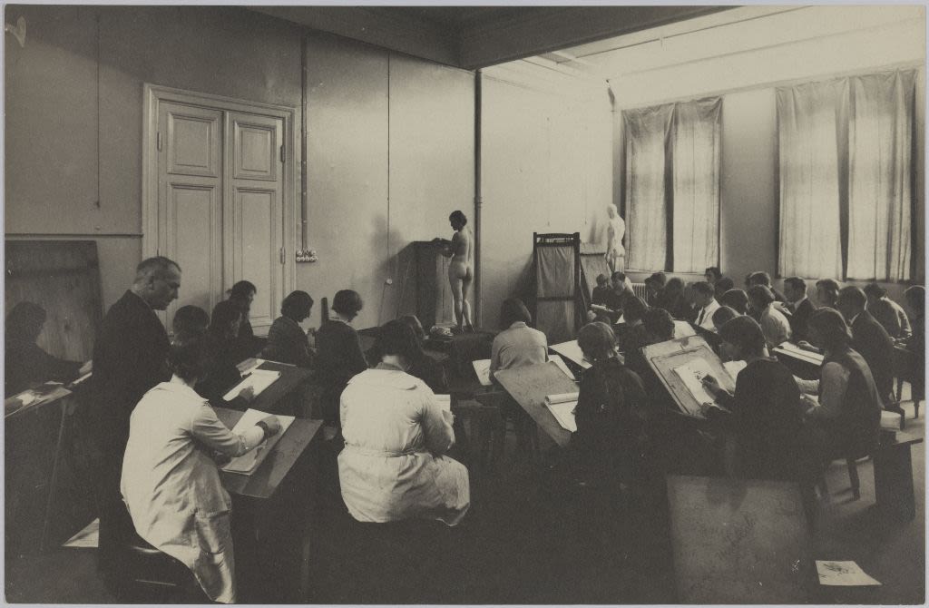 classroom full of students drawing live models.