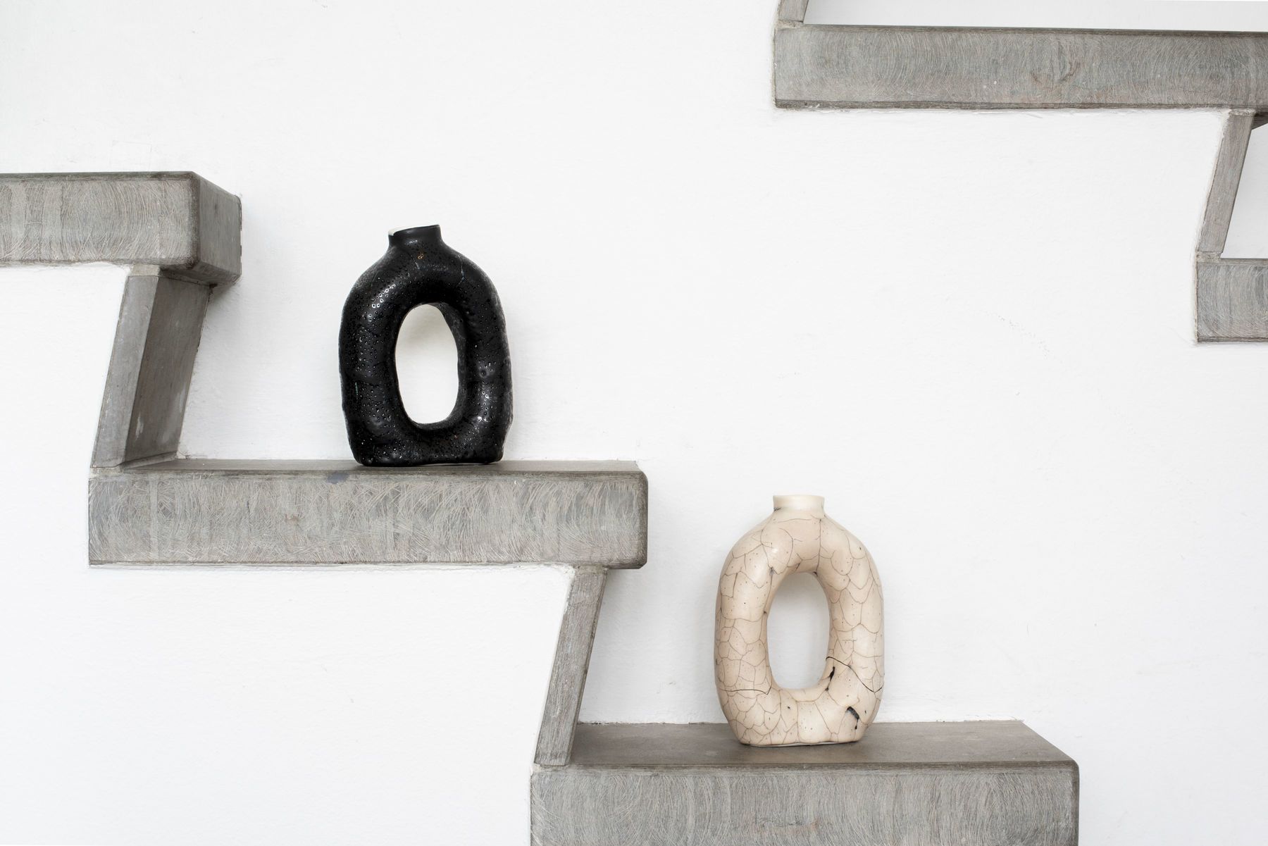 valkoinen ja musta keraaminen maljakko harmailla rapuilla