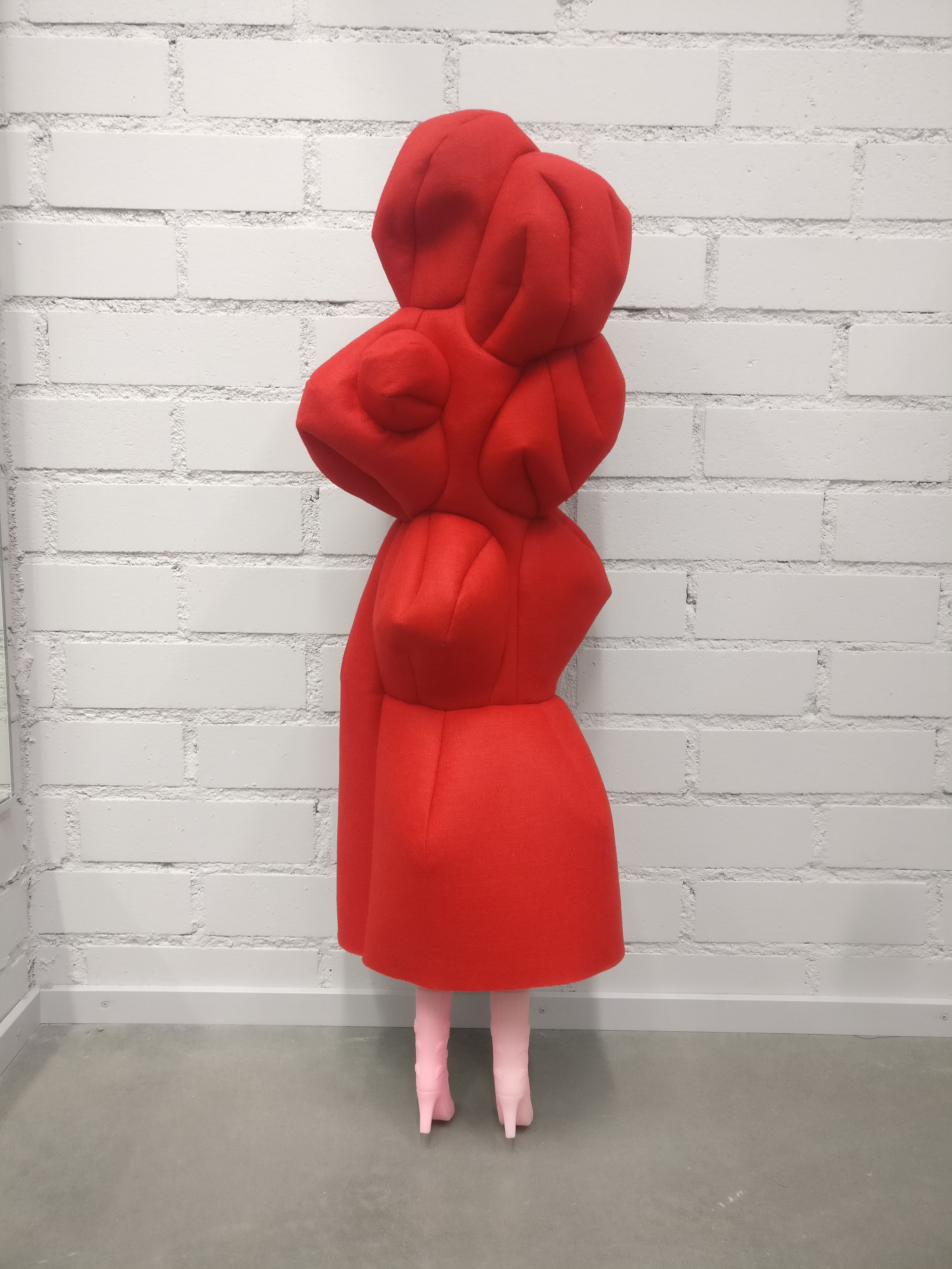 a miniature version of the red sculpted dress on a doll