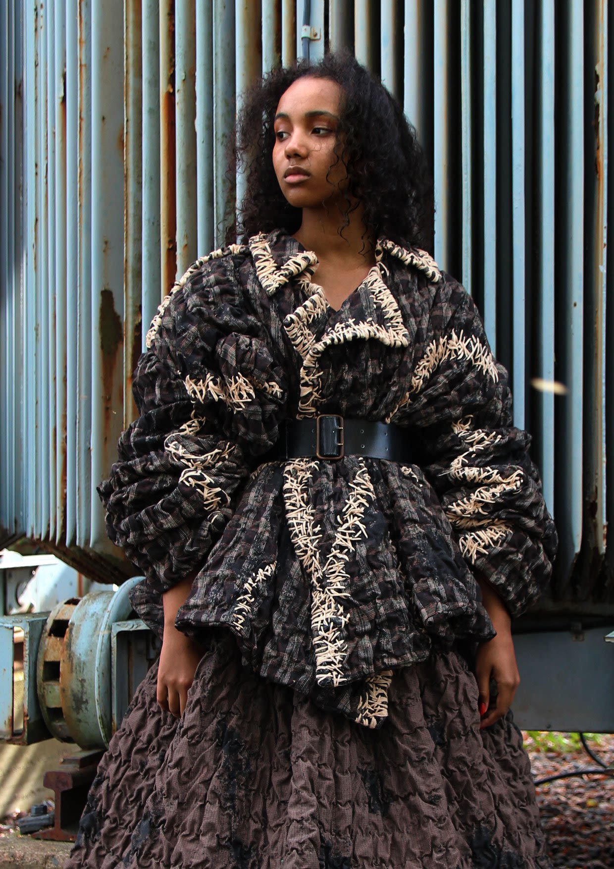 model wearing jacket and skirt in dark colors