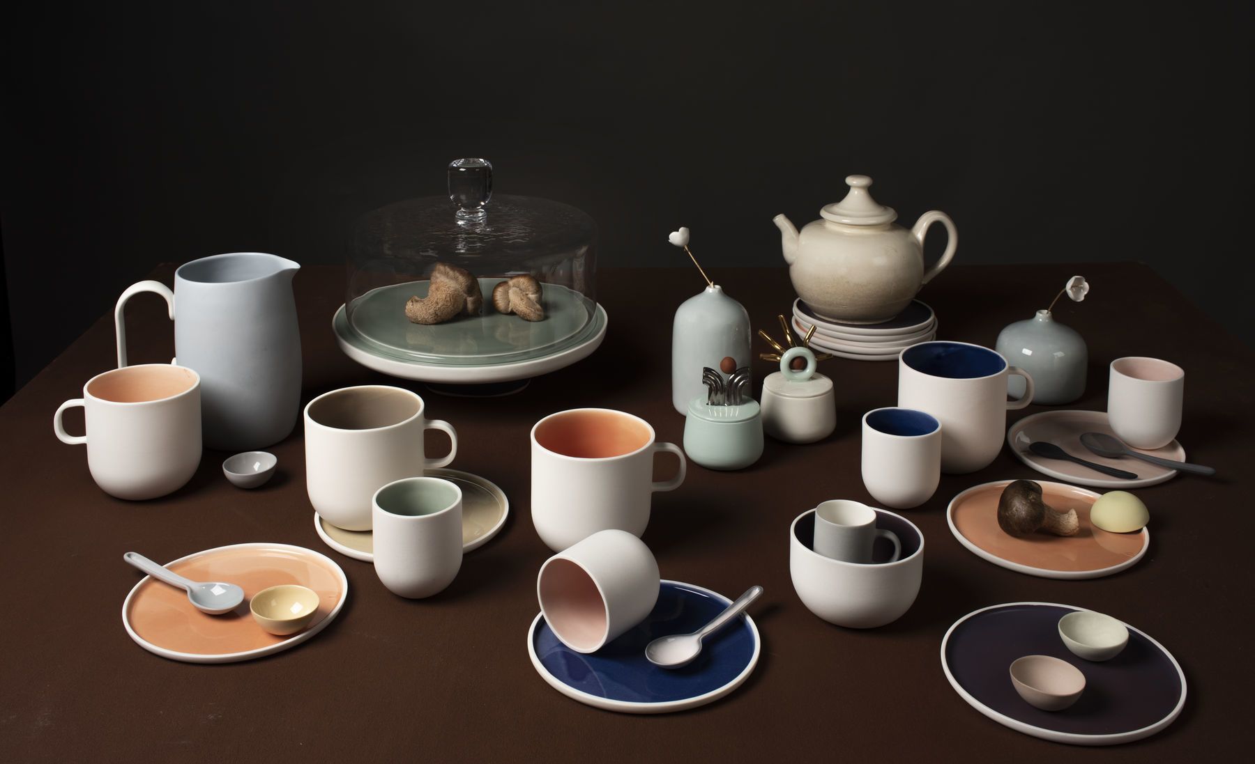 ceramic cups, mugs and plates together with other tableware in different colors.