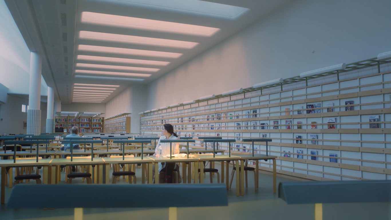 a woman sitting in an empty library reading room