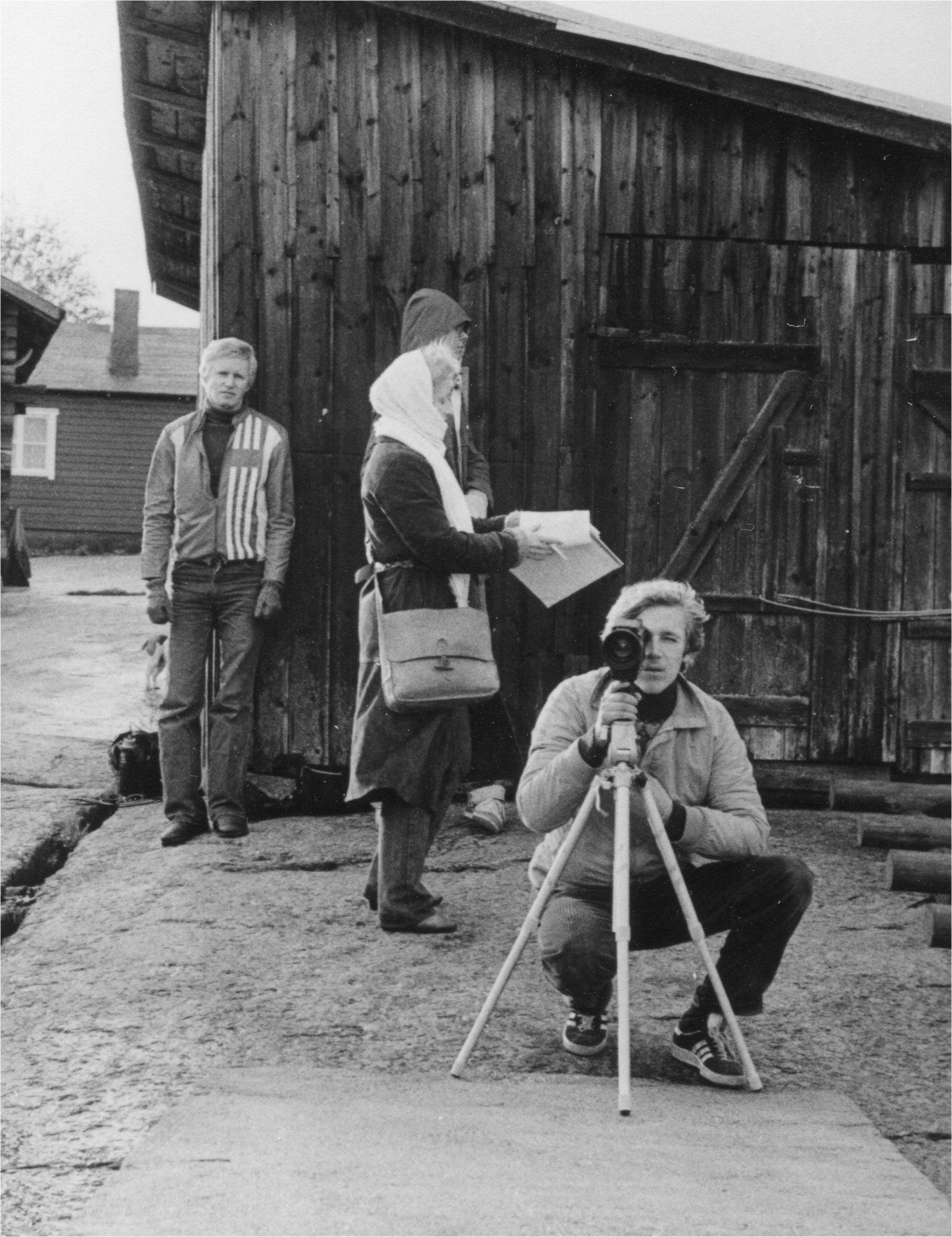 Four people on a film set with script and camera