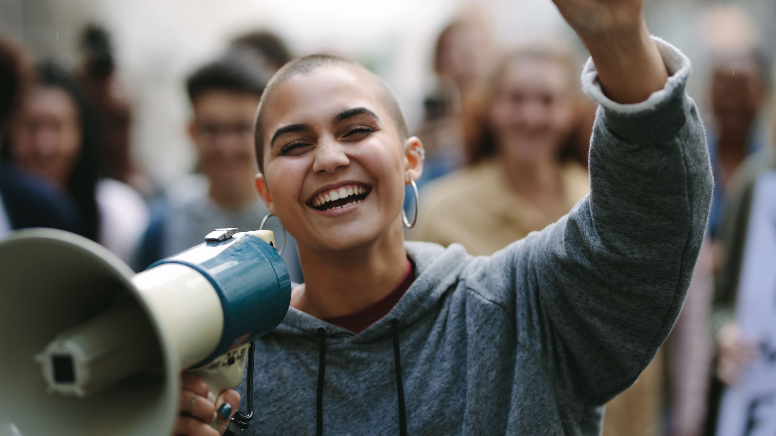 nainen hymyilee megafoni kädessä